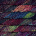 Multicolored yarn skeins stacked on a dark background