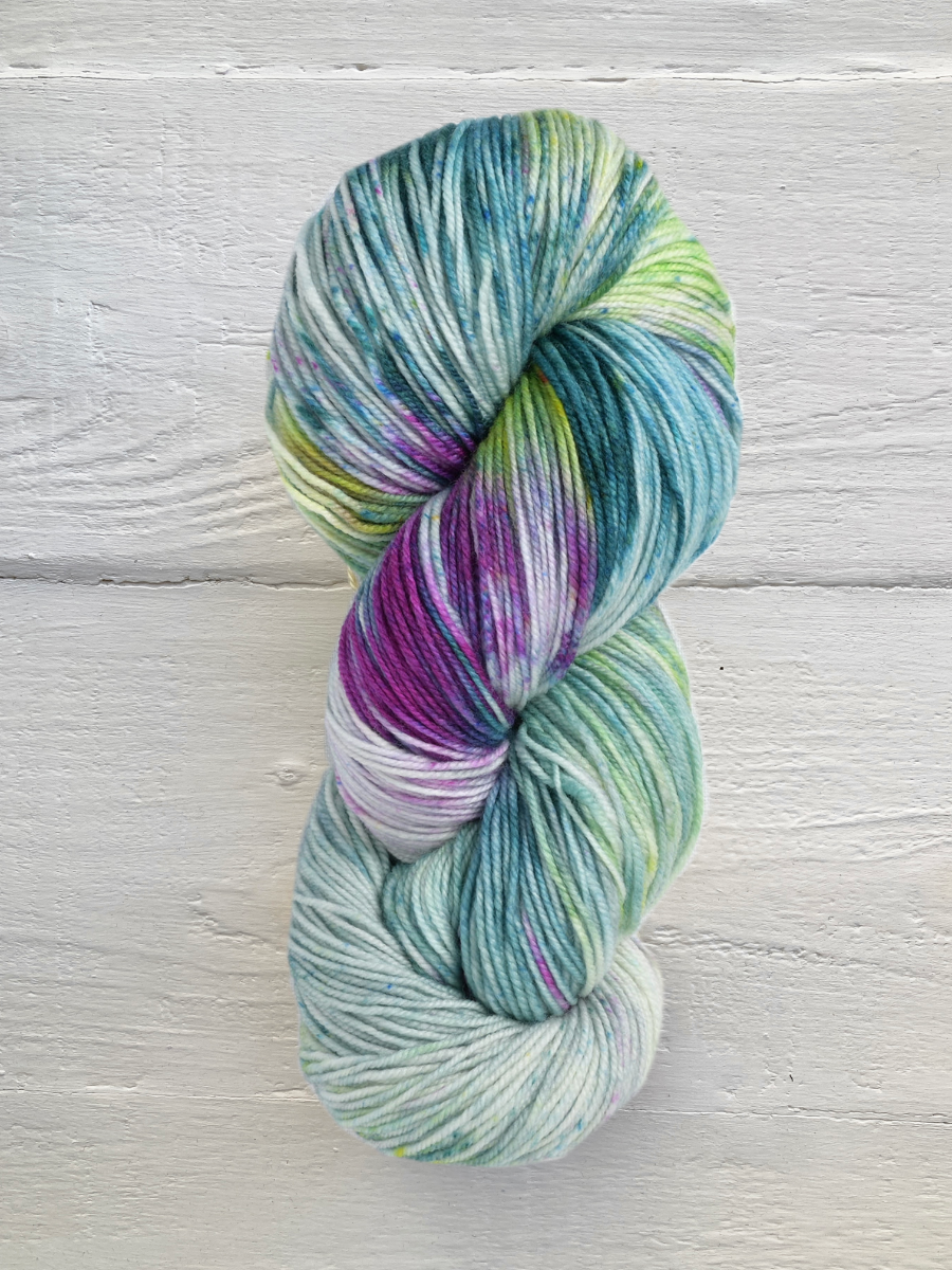 Multicolored skein of yarn on a light wooden surface