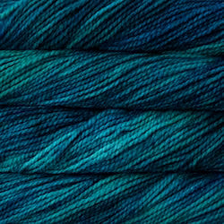 Close-up of variegated yarn strands in deep teal, blue, and green tones.
