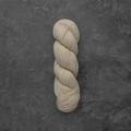 A single skein of cream-colored yarn twisted into a hank, displayed vertically against a dark textured gray background.