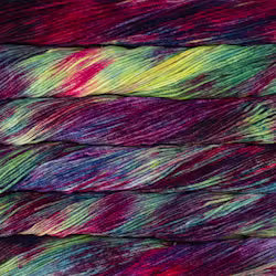A close-up of colorful yarn strands wound together, showing a marbled mix of deep purple, magenta, green, blue, and yellow tones.