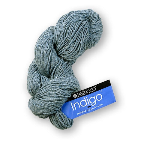 A skein of Berroco Indigo yarn in a dusty slate blue-gray color, with its blue and black brand label attached, on a plain white background.