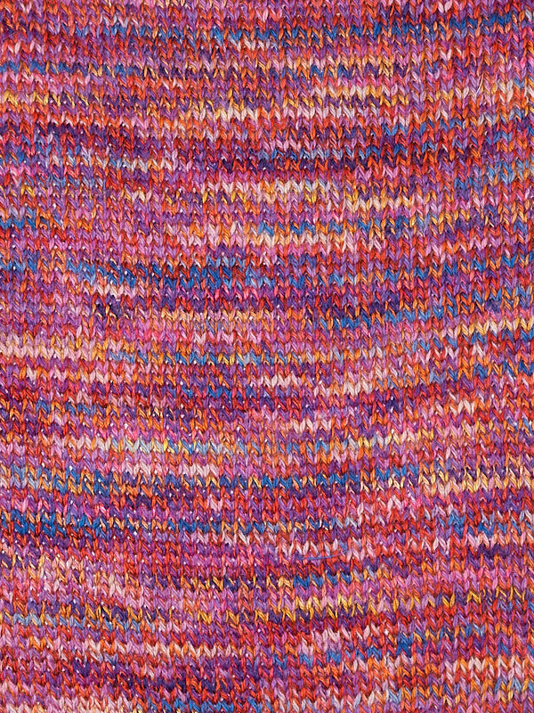 Close-up of a knitted fabric with a variegated pattern of pink, purple, orange, and blue yarns.