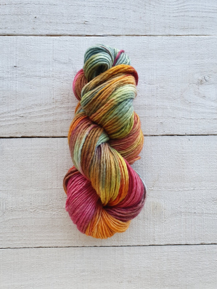 Multicolored skein of yarn on a light wooden surface