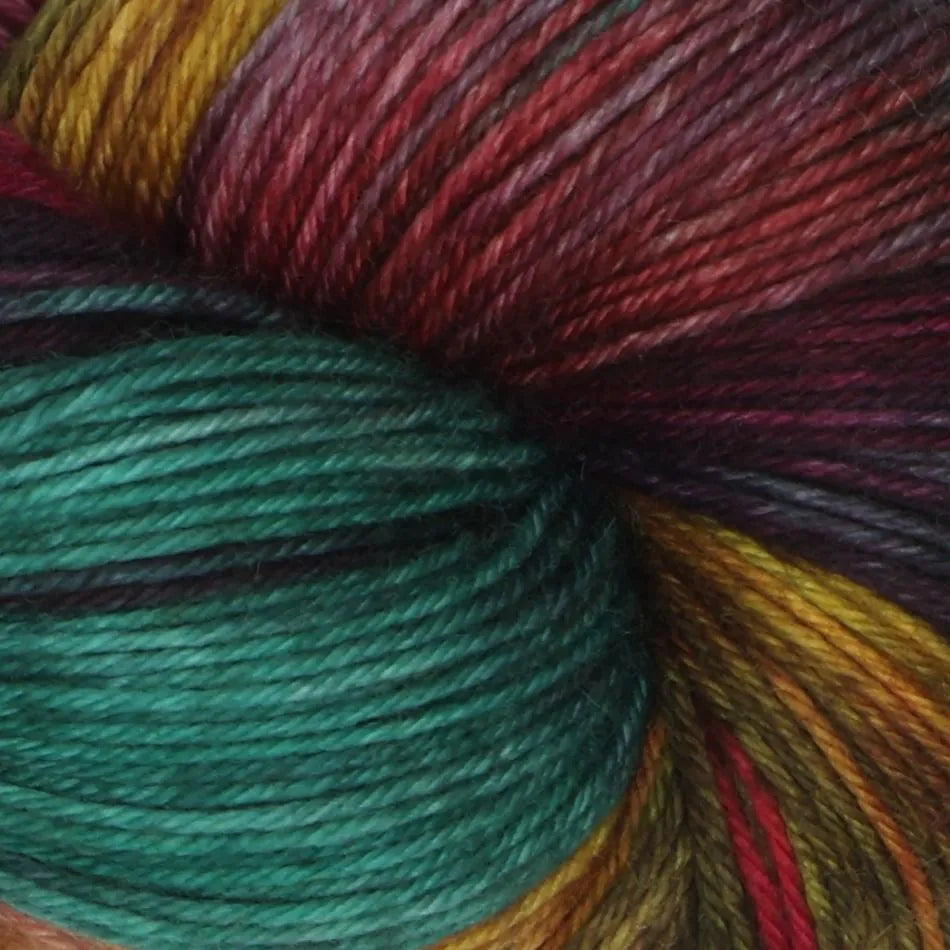 Close-up of multicolored yarn with a focus on green and red tones.