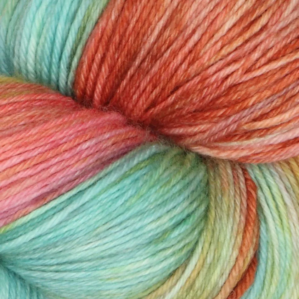Close-up of multicolored yarn with shades of orange, green, and pink.